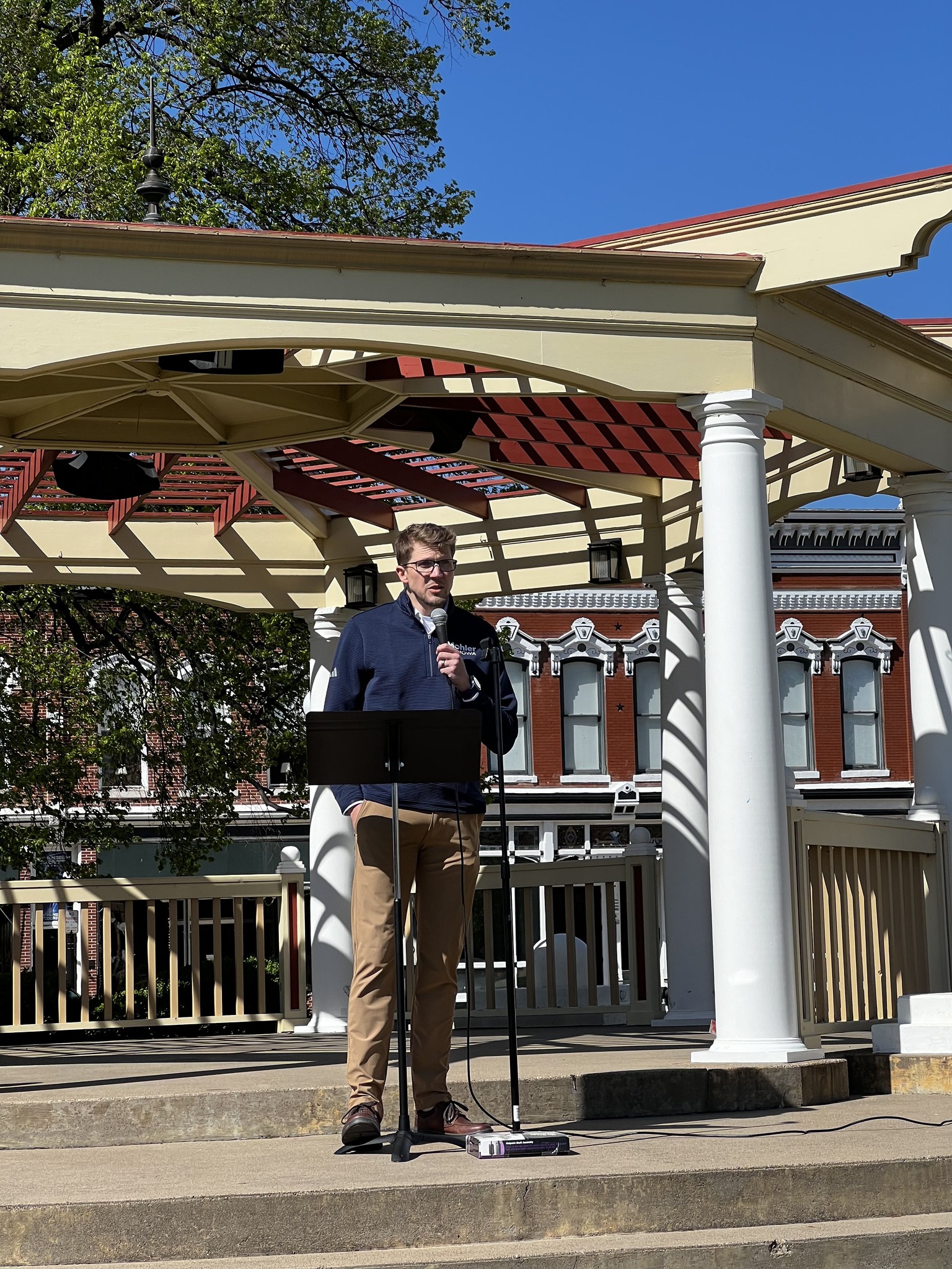 Brett Mohler speaking at an outdoor event in Iowa